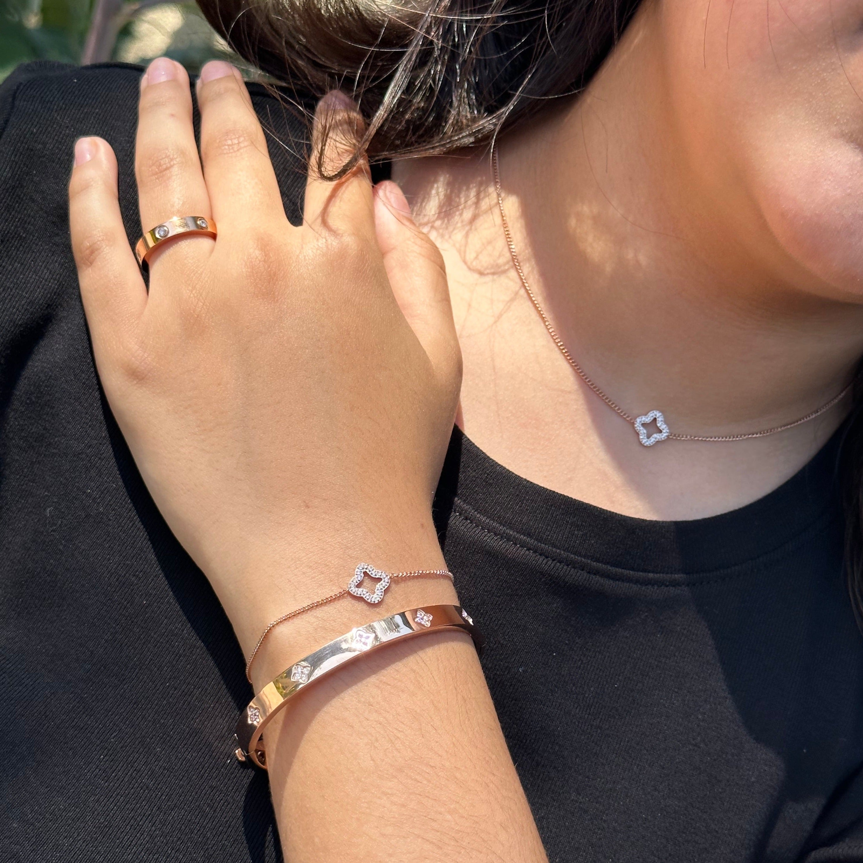 womens love ring paired with clover bracelets and necklace in rose gold