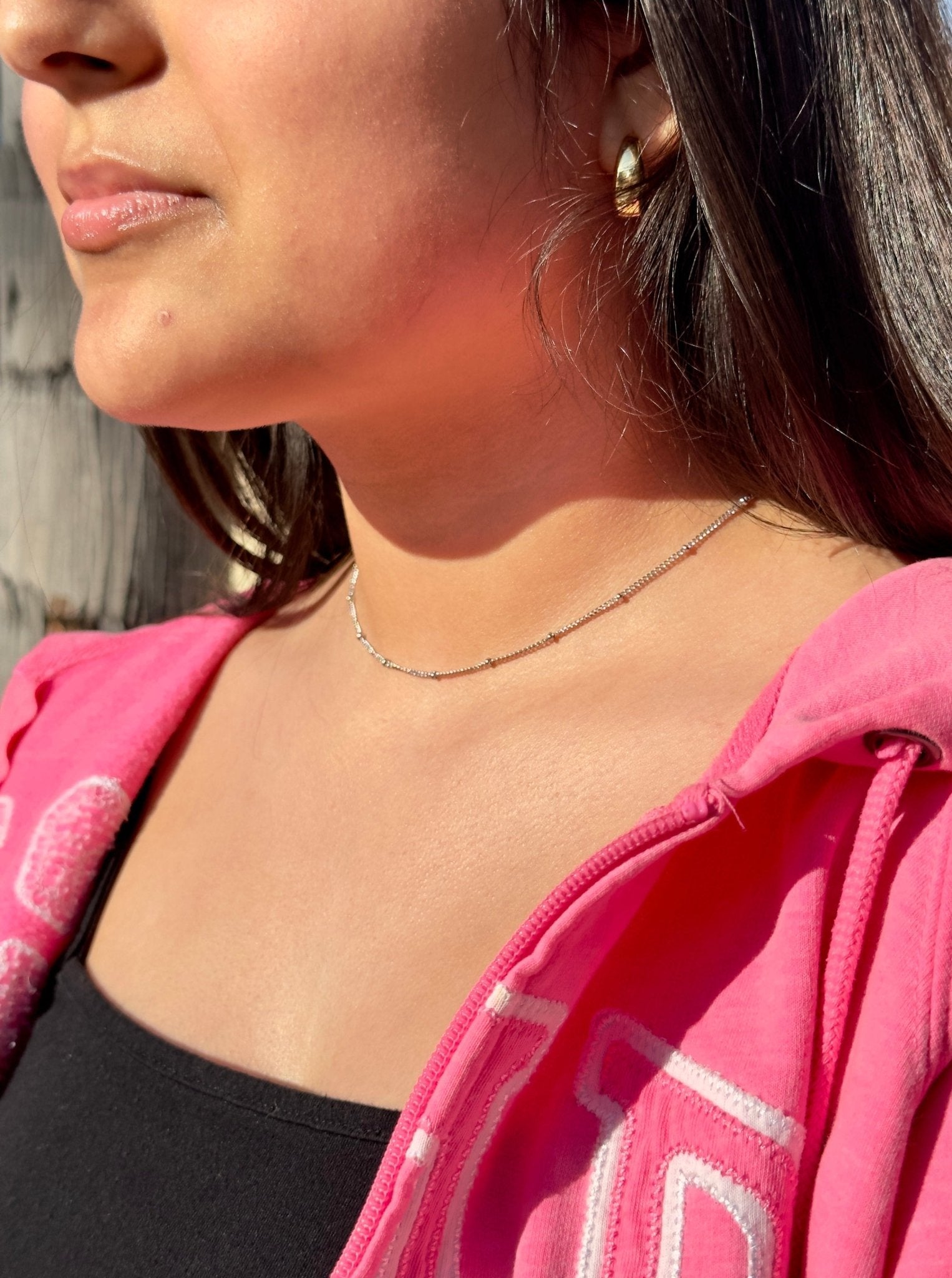dainty 1.2mm silver choker and gold earrings during golden hour
