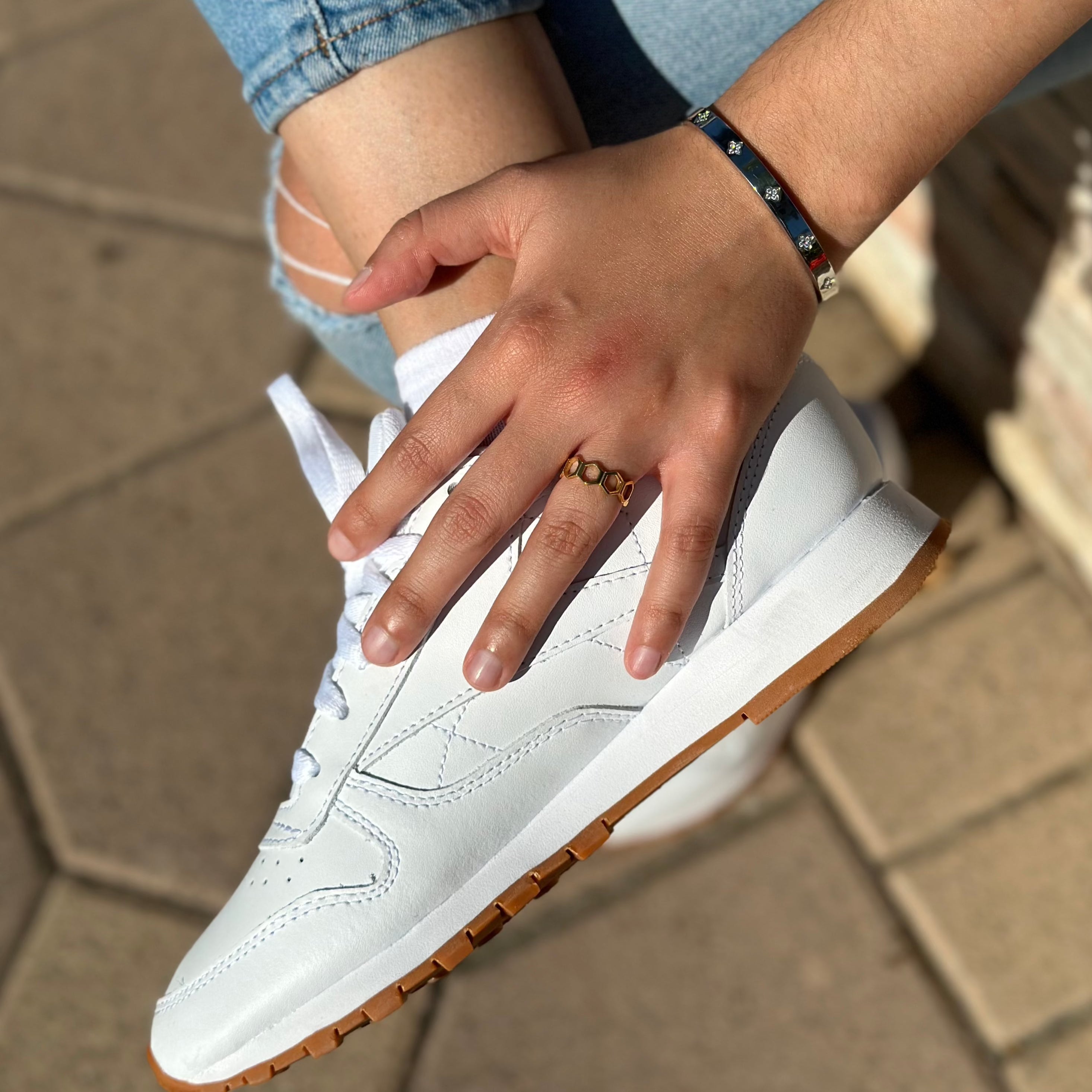 white reeboks paired with gold ring and bracelet
