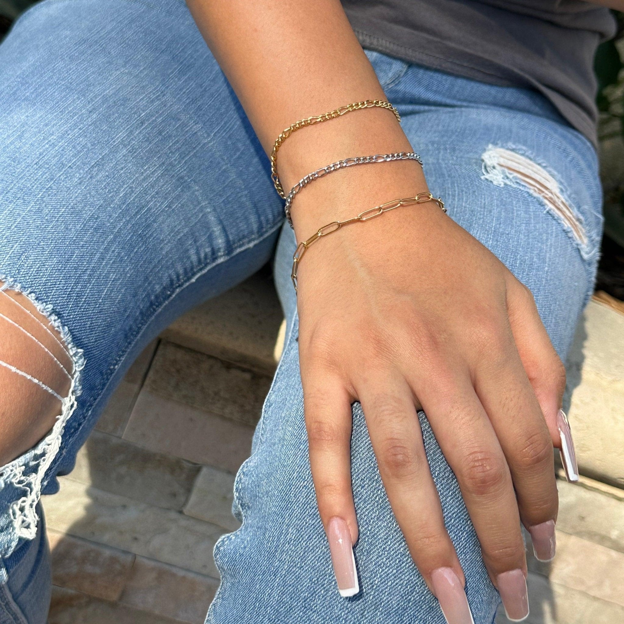 pink nails and a gold chain bracelets